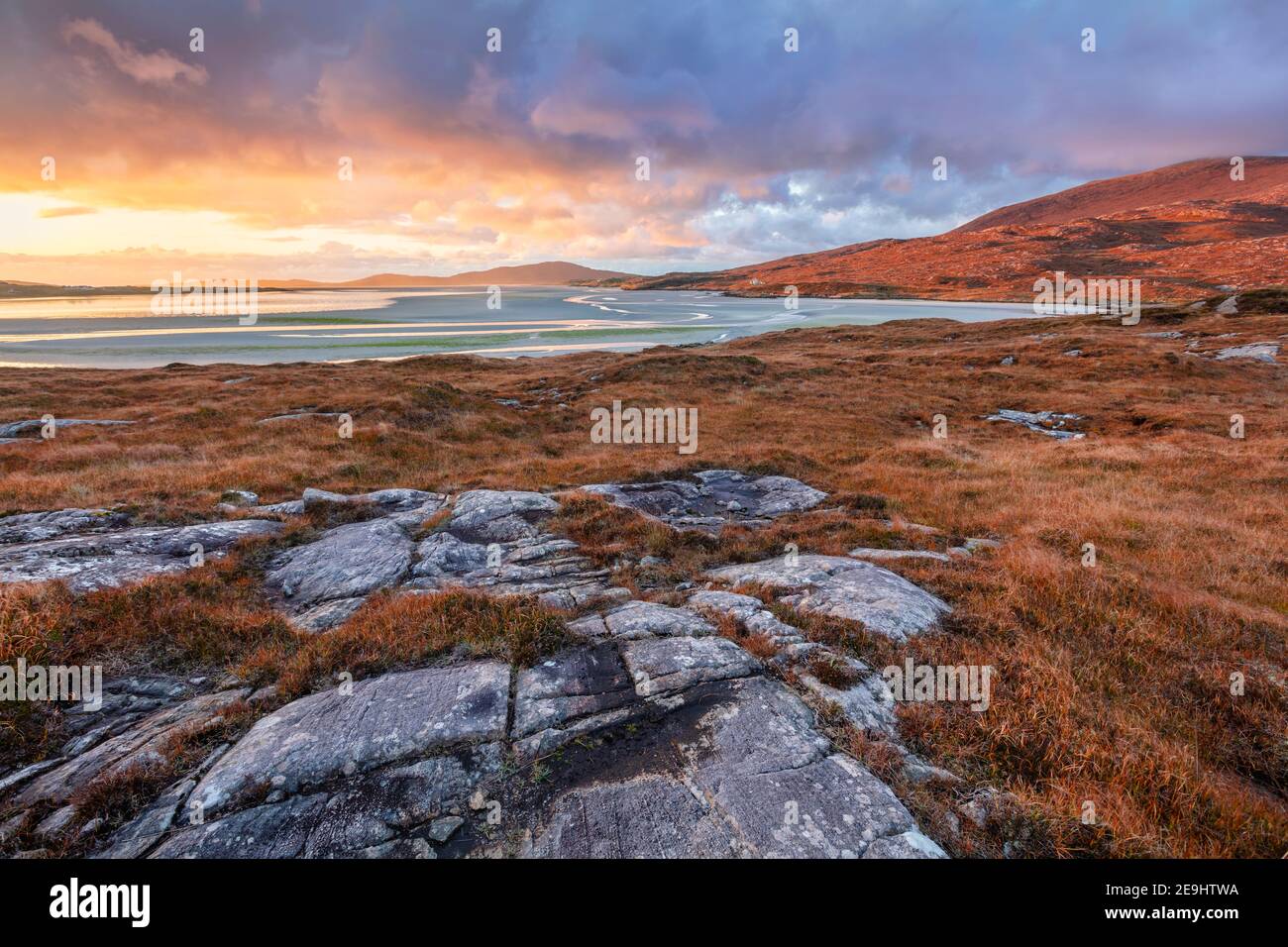 Isola di Lewis e Harris, Scozia: Massi ambientato nel machair con l'ampia distesa di Luskentire spiaggia al tramonto sull'isola di Harris Foto Stock