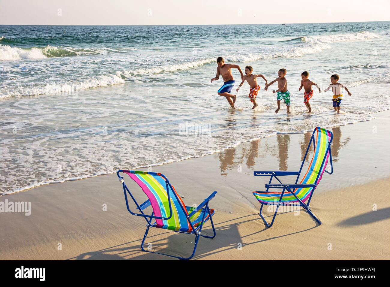 Alabama Orange Beach Golfo del Messico Costa surf, sedie pieghevoli sabbia ispanica famiglia padre figli ragazzi correre, Foto Stock