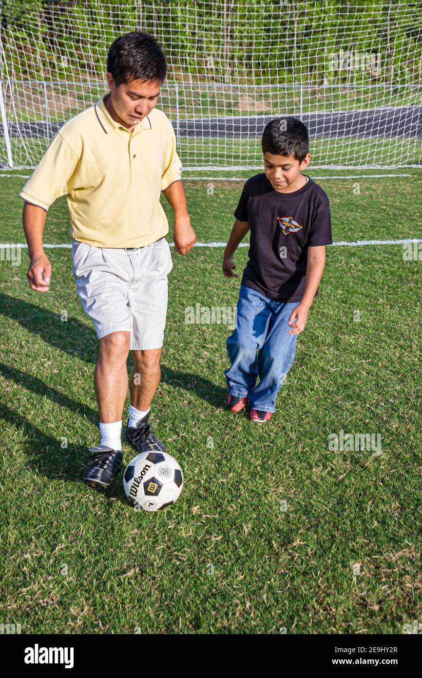 Birmingham Alabama,regioni Parco Ispanico padre figlio calcio palla, pratica calci dribbling, Foto Stock