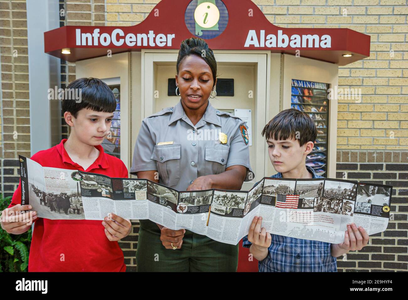 Alabama Scenic Highway 80 Selma a Montgomery Civil Rights Trail, centro interpretativo di Lowndes Black woman femminile parco ranger, ragazzi cercando cartella Foto Stock