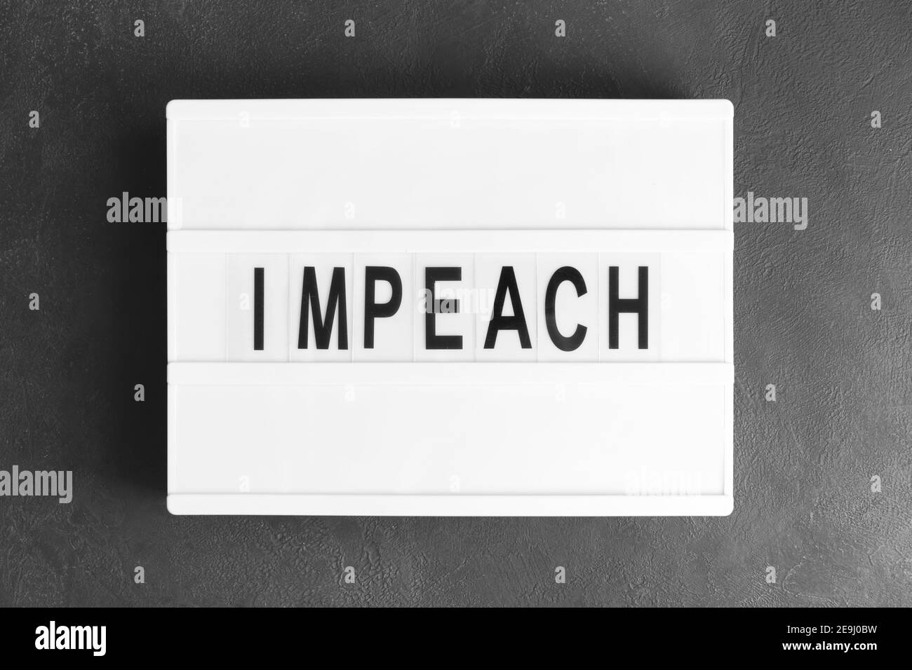 Bordo con la parola CHE IMPEDISCE su sfondo scuro Foto Stock