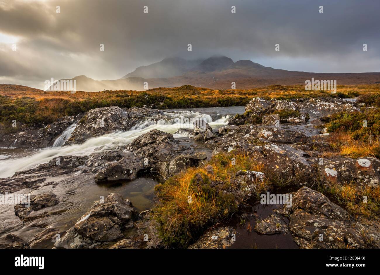 Isola di Skye, Scozia: Acque impetuose del fiume Sligachan e la luce che si infrangono sulle Black Cuillin Mountains in lontananza. Foto Stock
