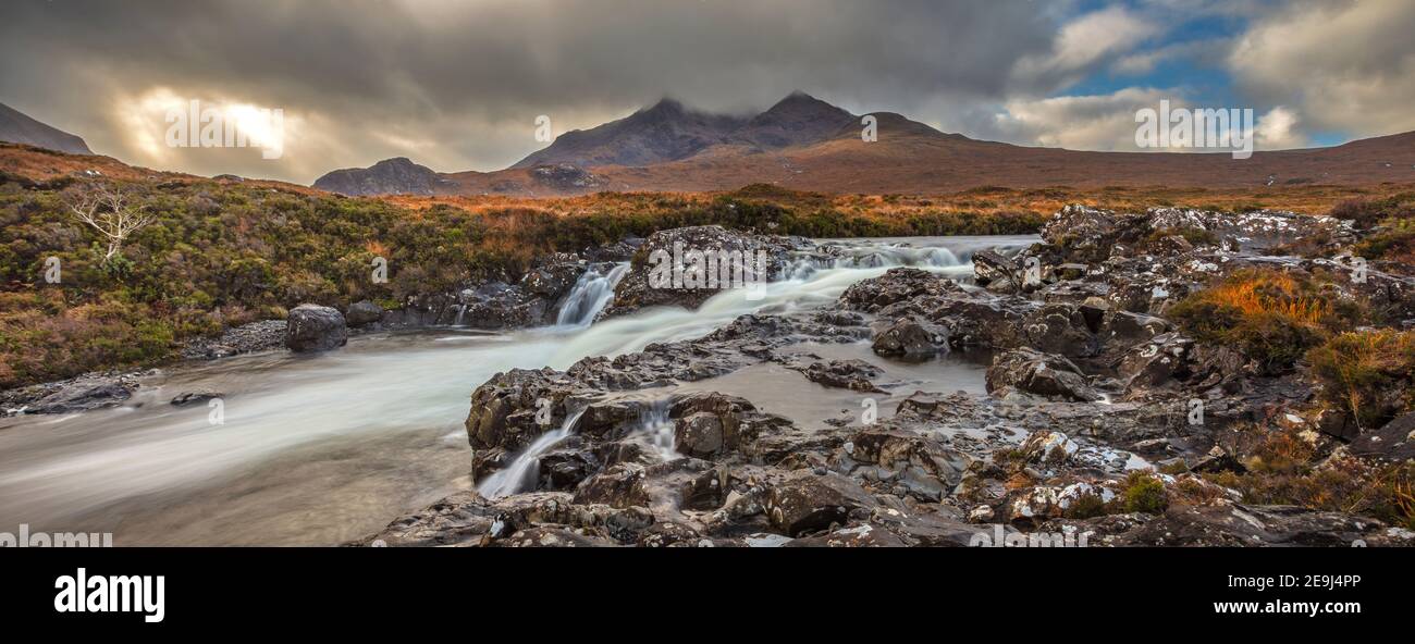 Isola di Skye, Scozia: Acque impetuose del fiume Sligachan con la luce che si infrangono sulle Black Cuillin Mountains in lontananza Foto Stock