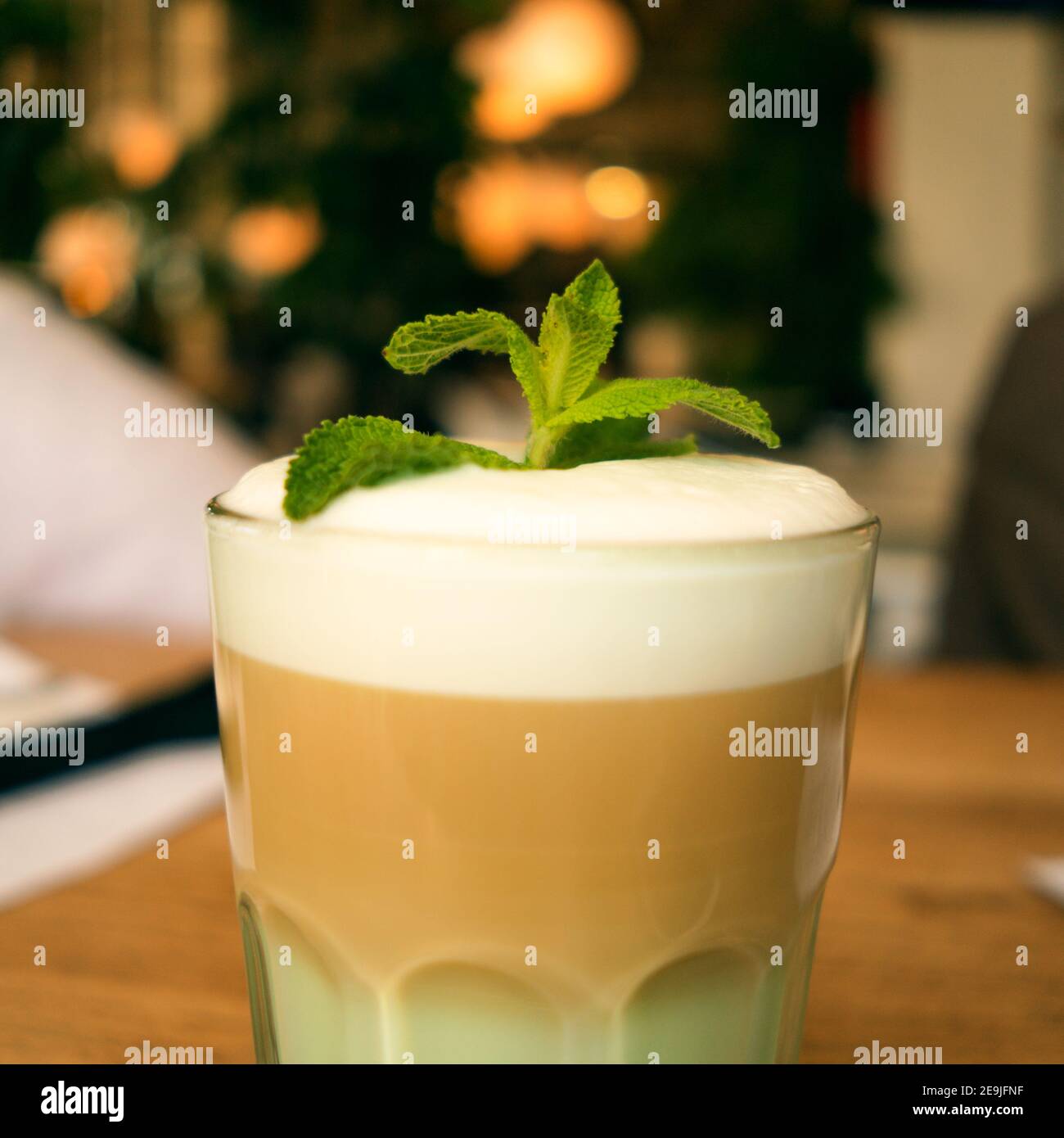 Bevanda preferita. RAF con latte, sciroppo, panna montata e foglie di menta. Un bicchiere di caffè. Primo piano. Foto Stock