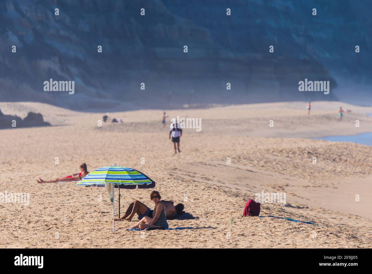 Portogallo, Praia Santa Rita Norte, 04 ottobre 2018: Persone che si rilassano sulla spiaggia di sabbia sotto gli ombrelloni. Foto Stock
