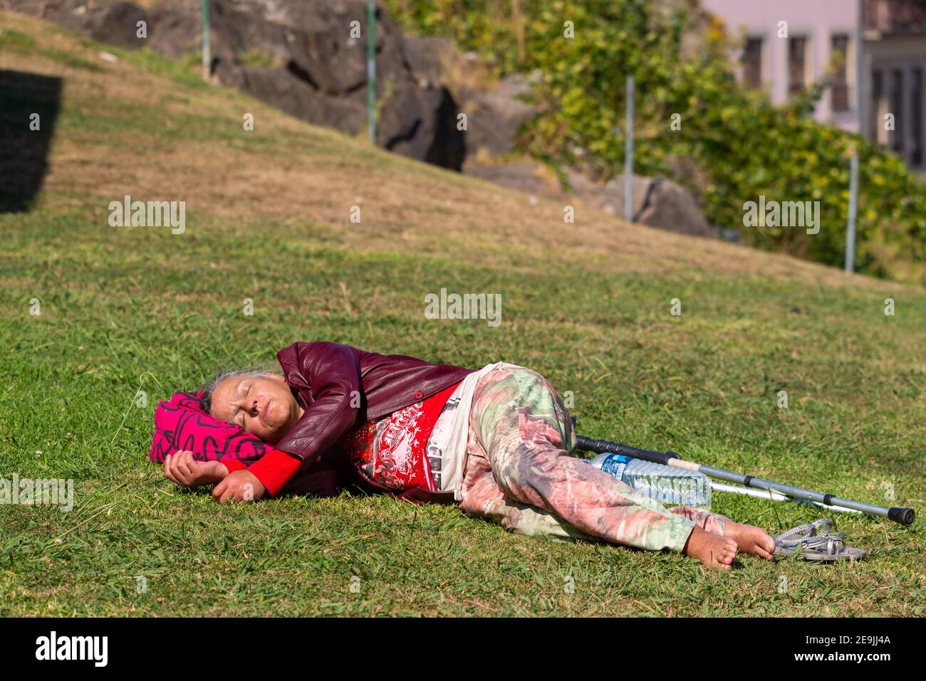 Portogallo, Porto, 06 ottobre 2018: Donna anziana con crostate bugie e dormire su erba verde nel parco. Foto Stock