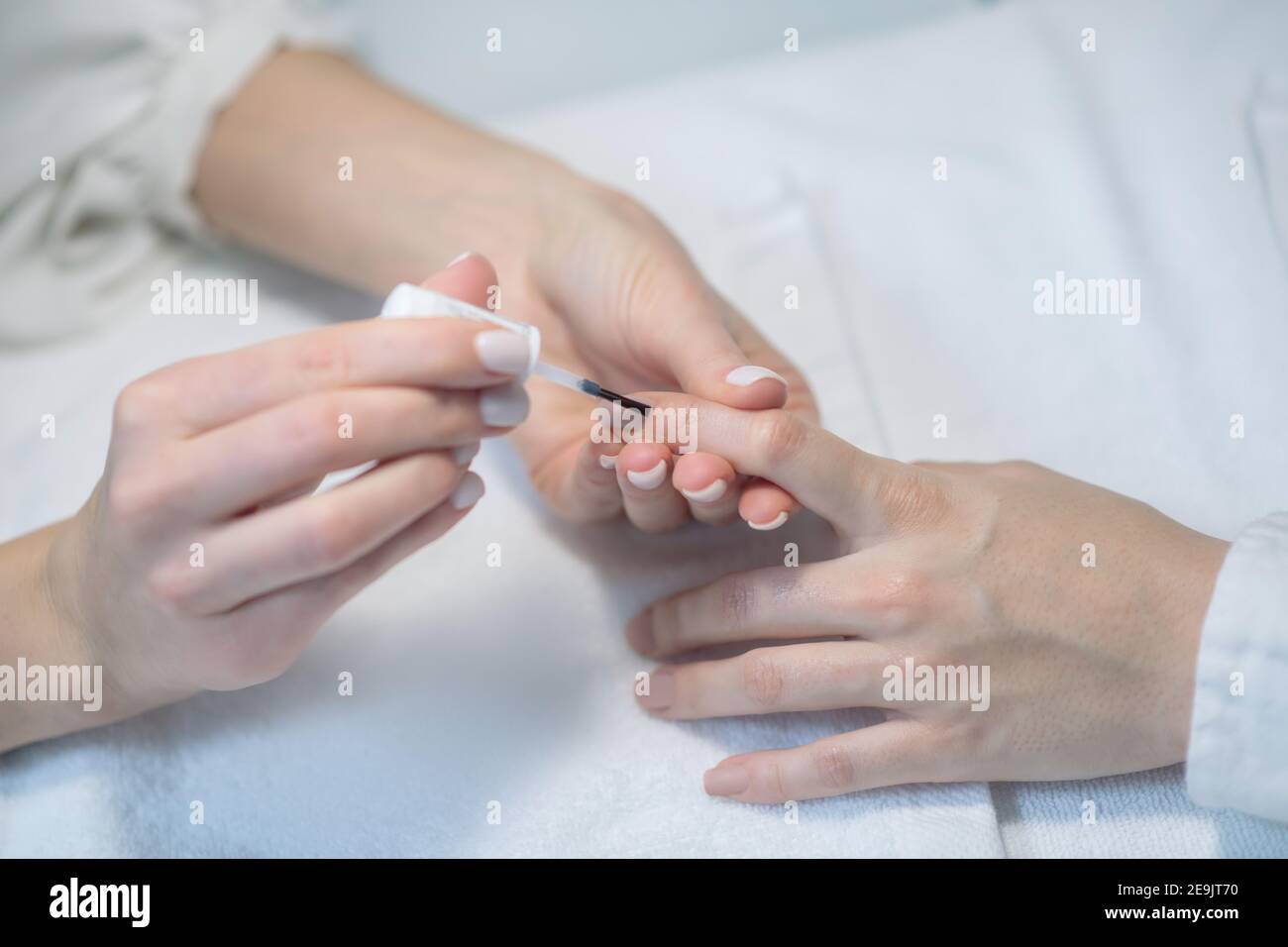 Primo piano immagine di unghie artisti mani in guanti facendo lucidatura unghie Foto Stock