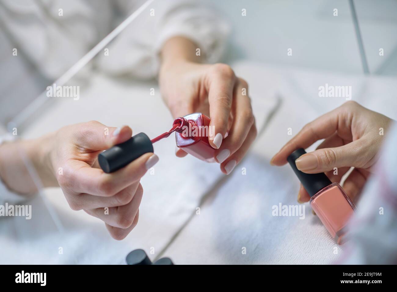 Primo piano immagine di unghie artisti mani apertura di una bottiglia con gommalacca Foto Stock