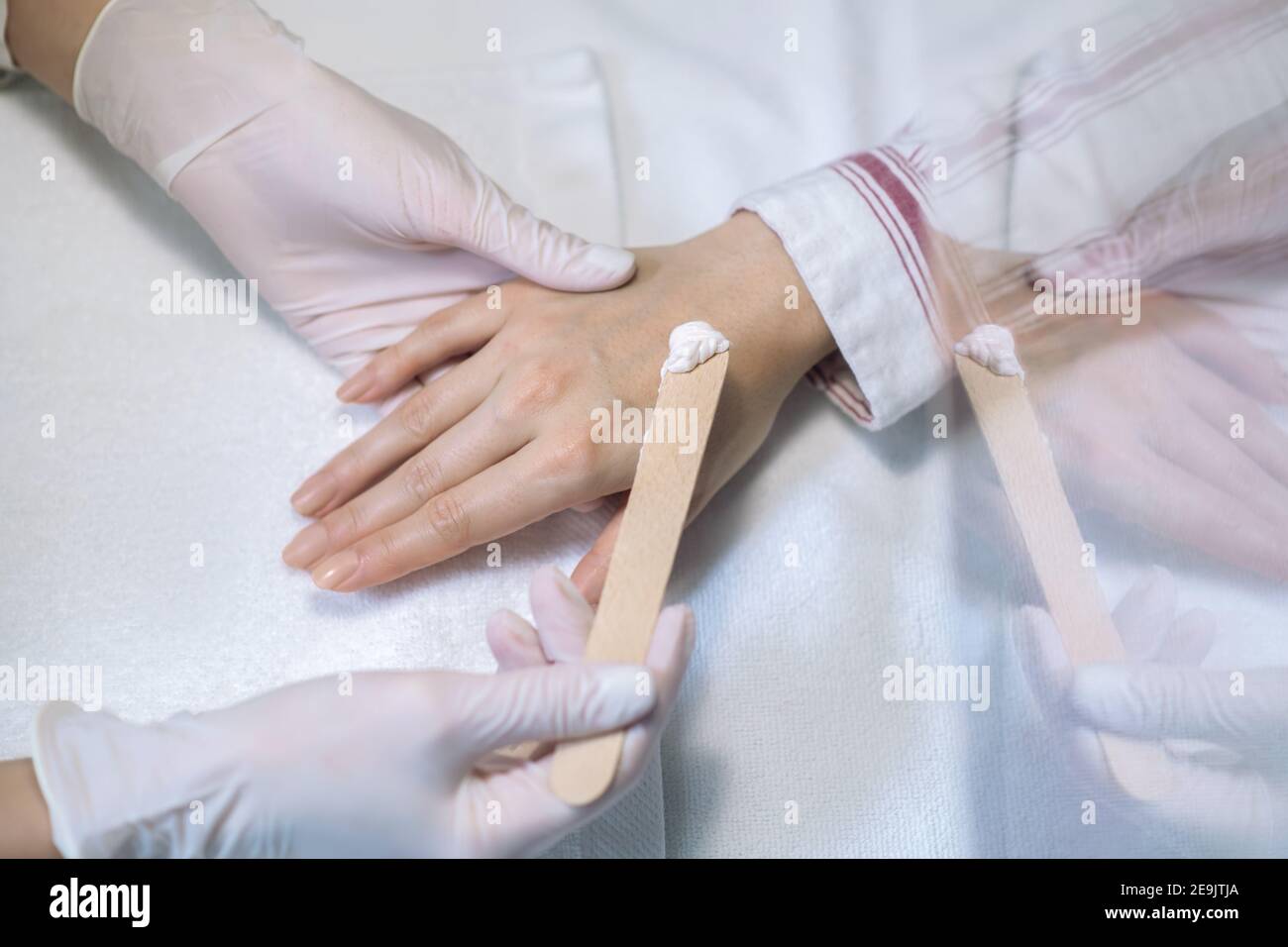 Primo piano immagine delle mani in guanti applyng crema su una mano Foto Stock