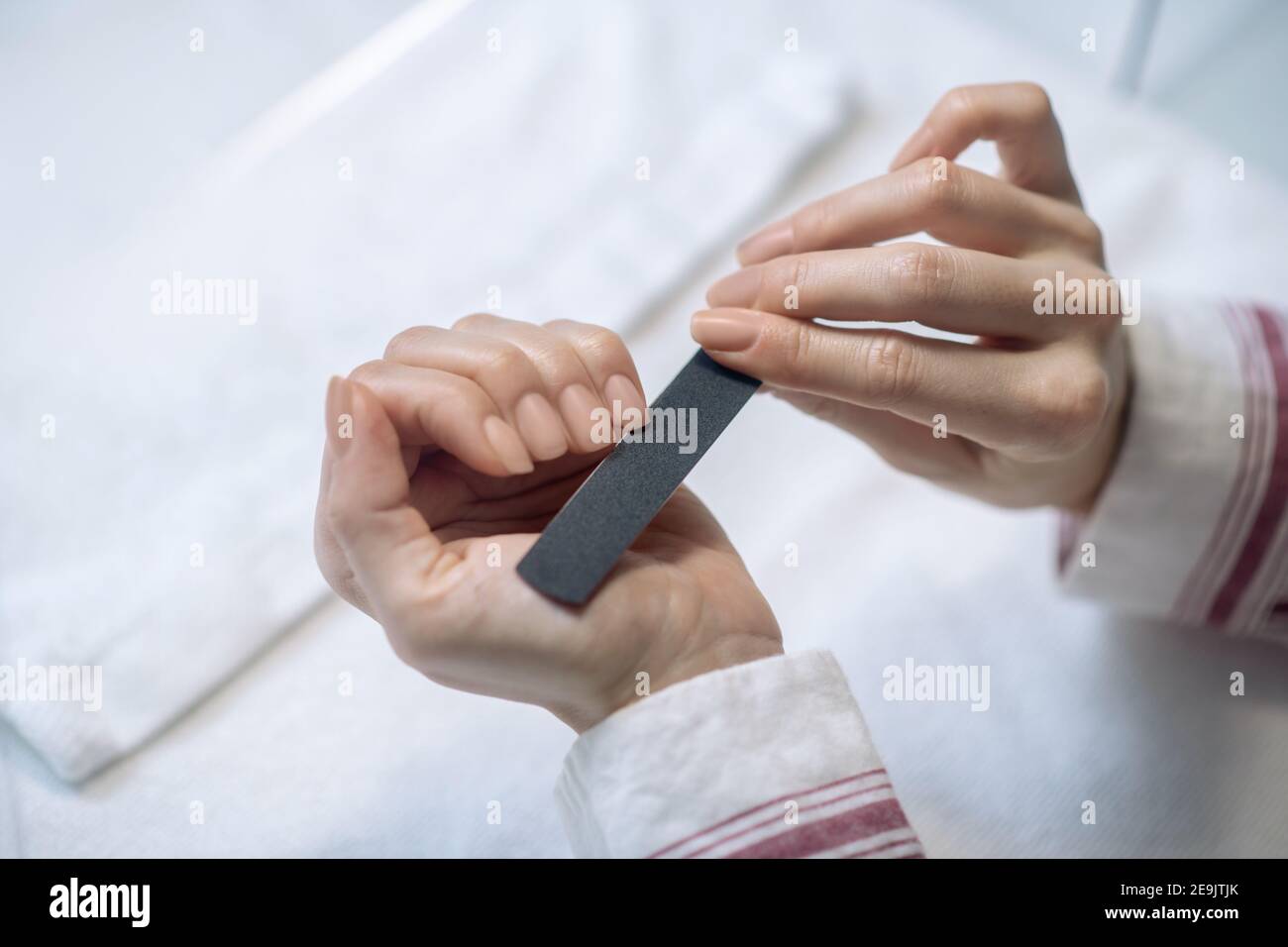 Primo piano immagine di mani femmina limando unghie Foto Stock