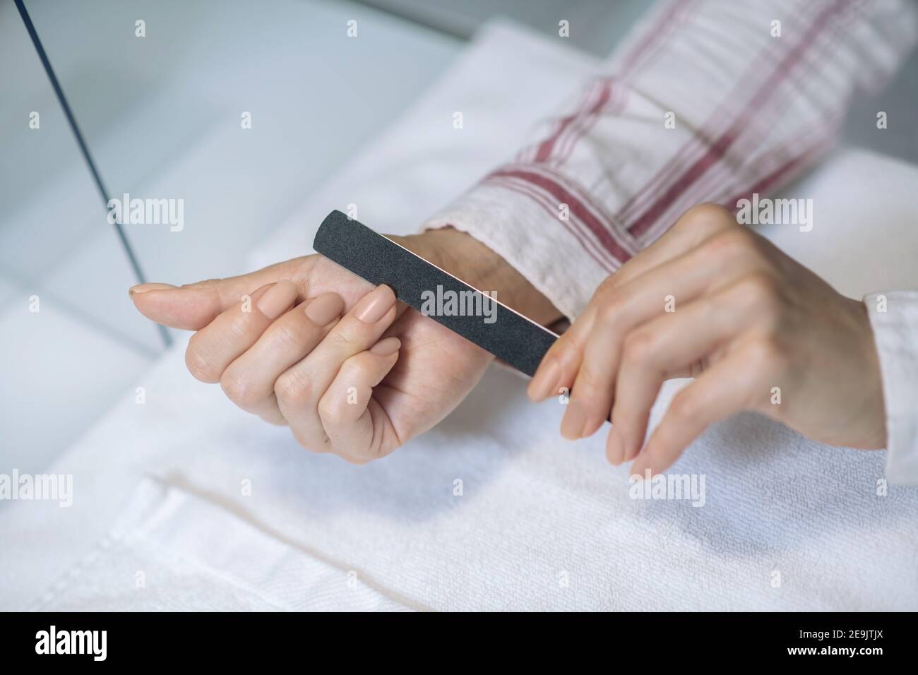 Primo piano immagine di mani femmina limando unghie Foto Stock