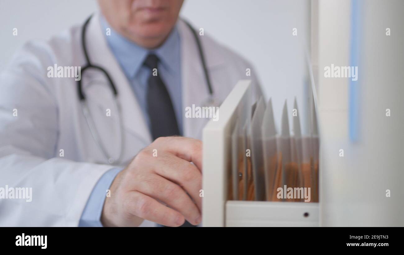 Immagine con un medico che cerca le cartelle cliniche nell'archivio ospedaliero. Foto Stock