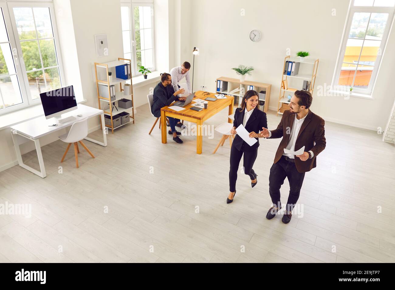 Spazio di lavoro creativo con i giovani che lavorano su progetti, condividono notizie, discutono di temi di lavoro Foto Stock