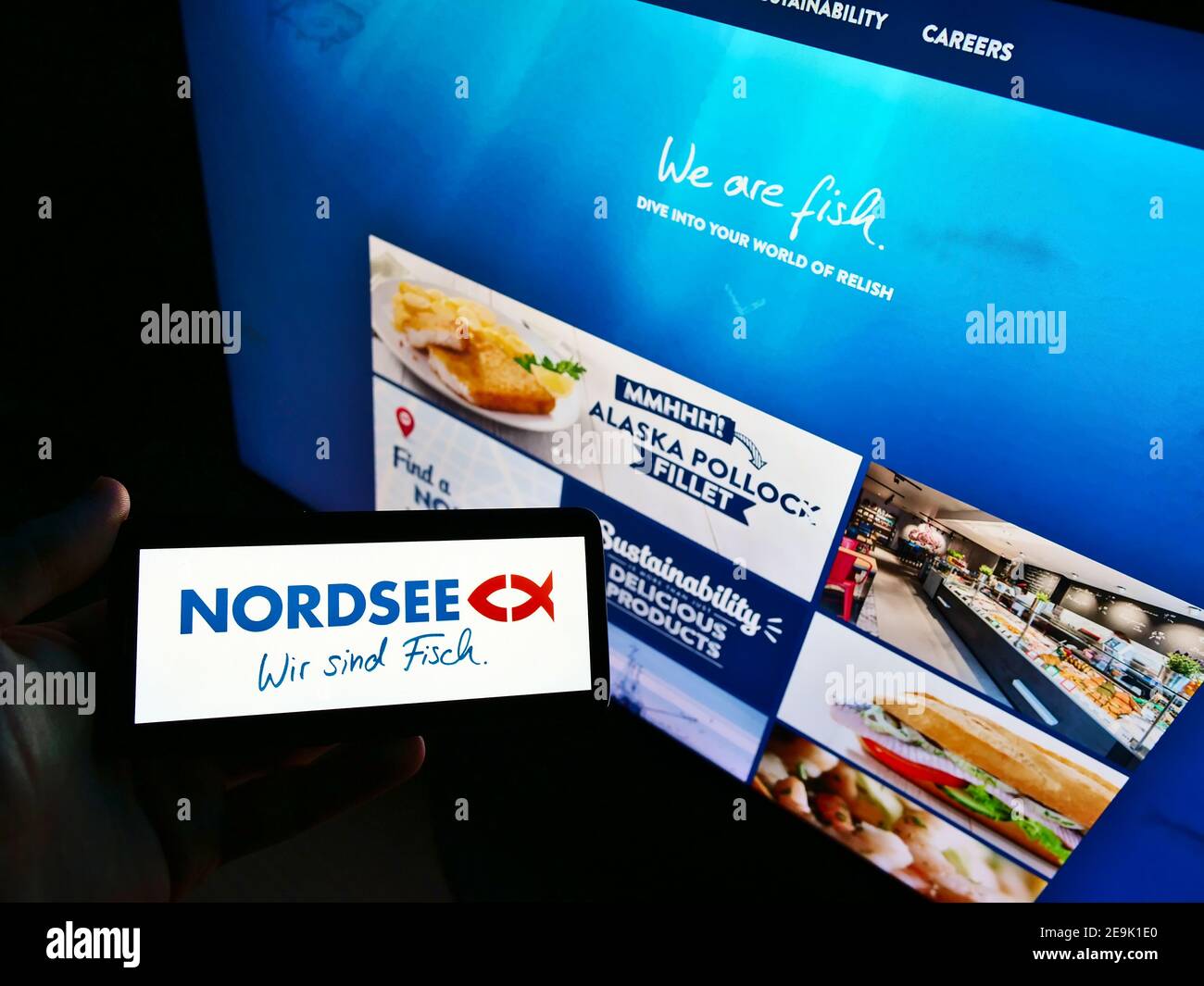 Persona in possesso di smartphone con il logo della catena di ristoranti tedesco di fast food Nordsee GmbH in esposizione davanti al sito Web aziendale. Mettere a fuoco lo schermo del telefono. Foto Stock