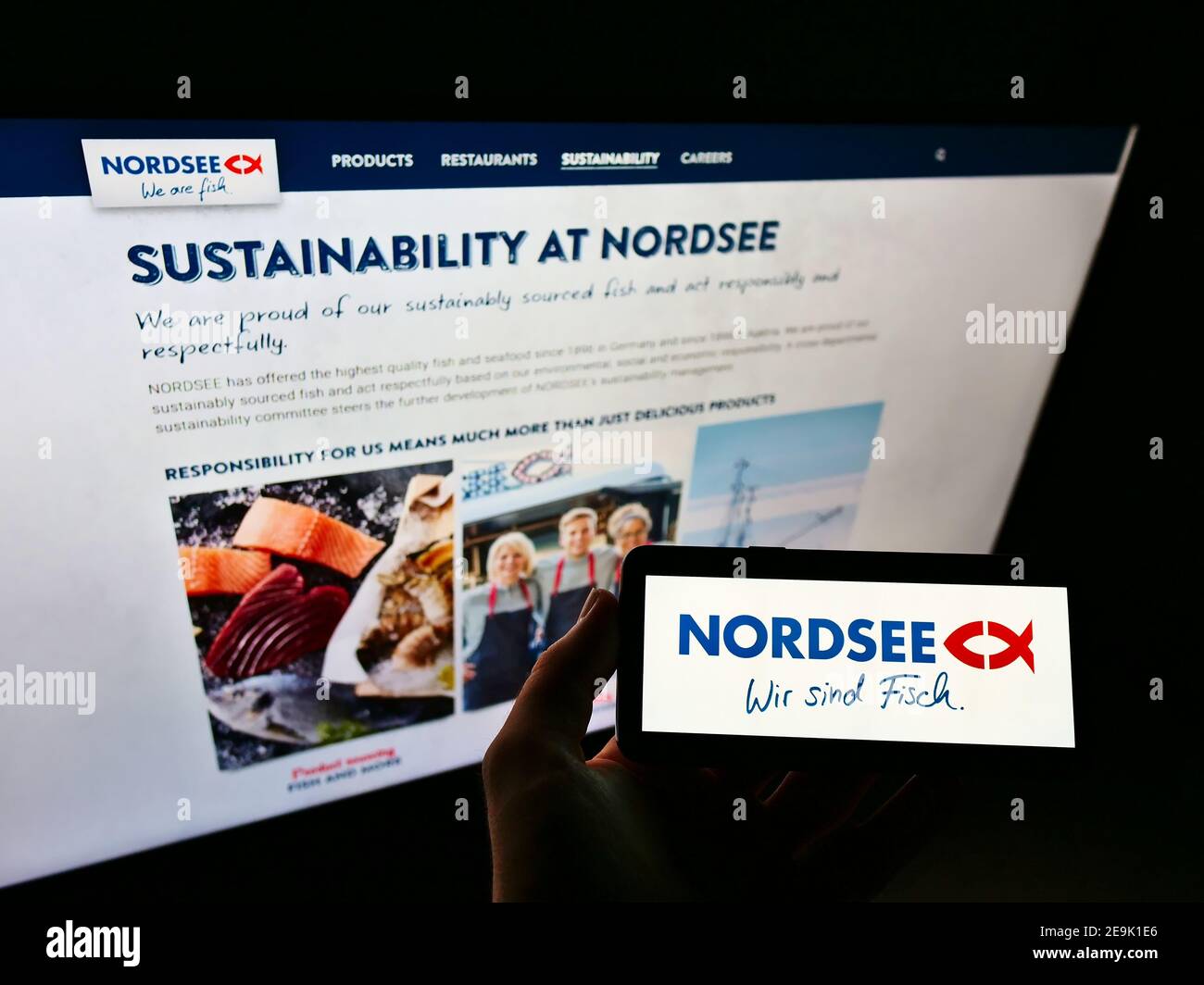 Persona che tiene il telefono mobile con il logo della catena tedesca di ristoranti fast-food Nordsee GmbH in esposizione davanti alla pagina web. Mettere a fuoco sullo schermo del cellulare. Foto Stock