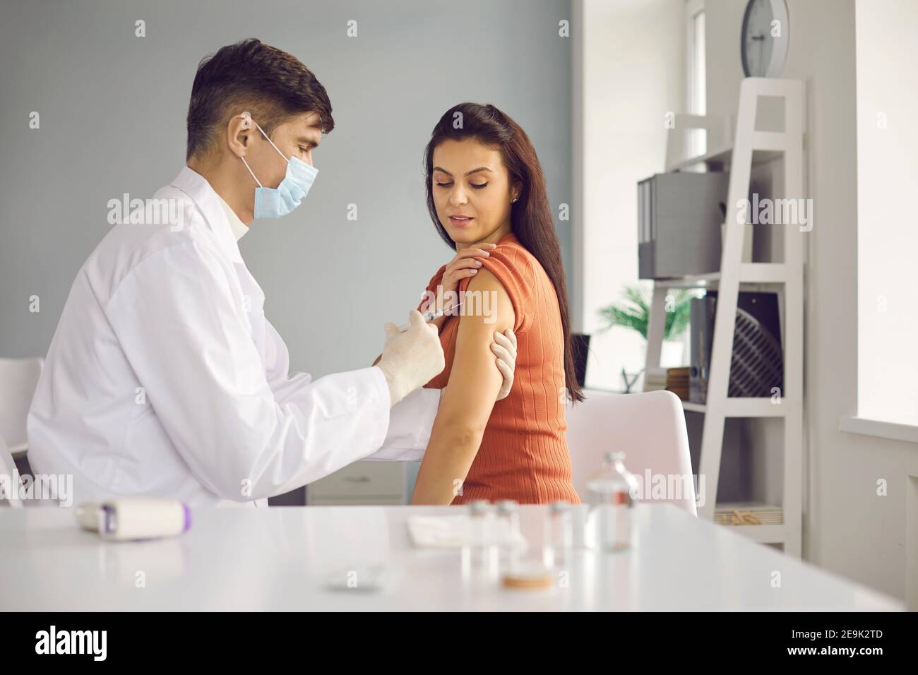 Medico che dà un vaccino ad una donna per l'influenza stagionale o un focolaio di un'infezione. Foto Stock