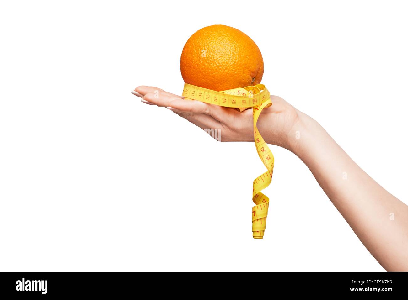 Tenere a mano frutta arancione organica fresca e nastro di misurazione isolato su sfondo bianco Foto Stock