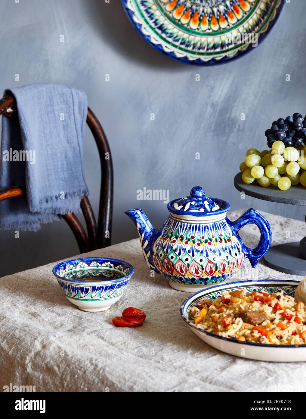 Usbeco cibo tradizionale pilaf, tè verde e frutta in piatto nazionale durante il festival di Nauryz su sfondo blu scuro Foto Stock
