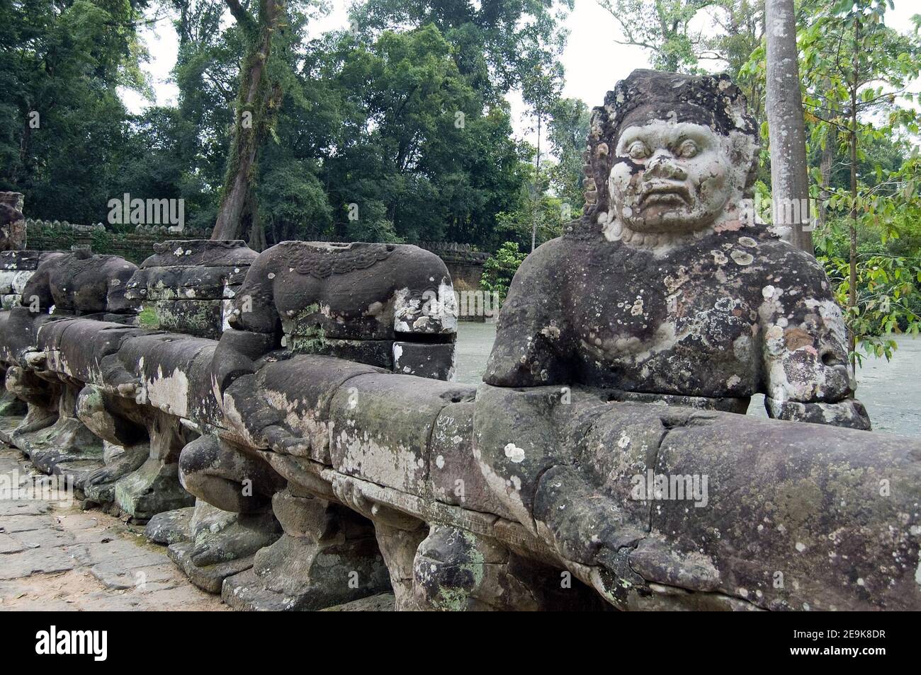 Antiche statue Khmer di Asura, o diavoli, che tirano il serpente Naga attraverso il fossato del tempio di Preah Khan, Siem Reap. Foto Stock