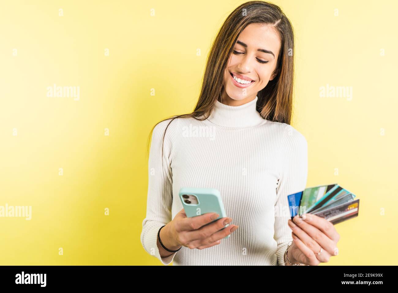 Giovane donna con carta di credito che acquista online con smartphone Foto Stock