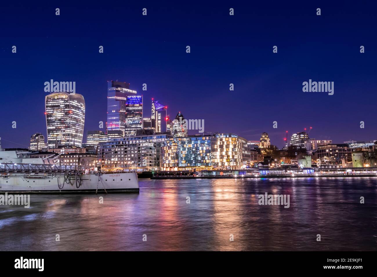 Il paesaggio urbano di Londra durante la vista notturna della città di Londra dall'altra parte del fiume Tamigi, la vita notturna nella capitale del Regno Unito, molte luci e riflessi dentro Foto Stock