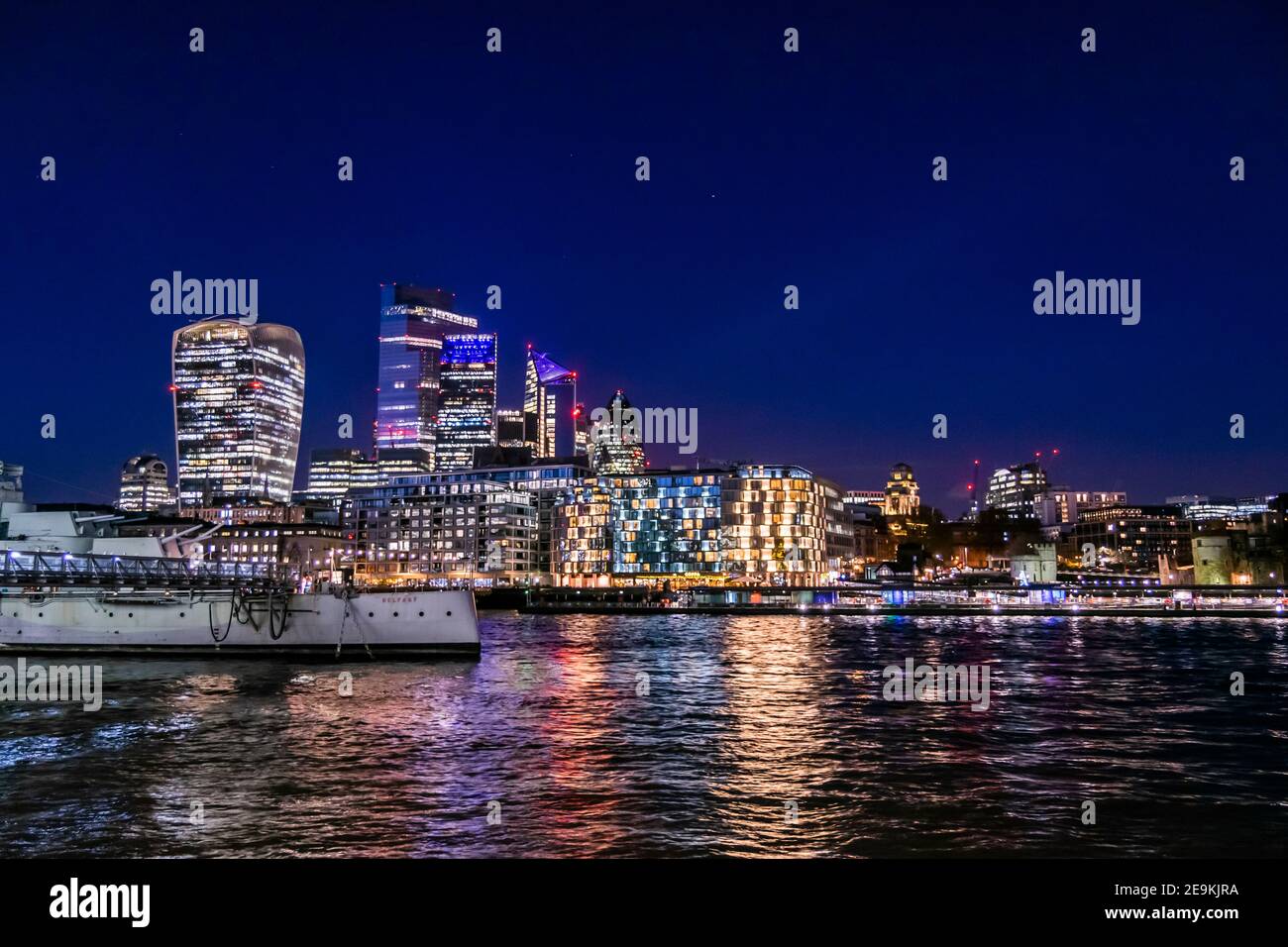 Il paesaggio urbano di Londra durante la vista notturna della città di Londra dall'altra parte del fiume Tamigi, la vita notturna nella capitale del Regno Unito, molte luci e riflessi dentro Foto Stock
