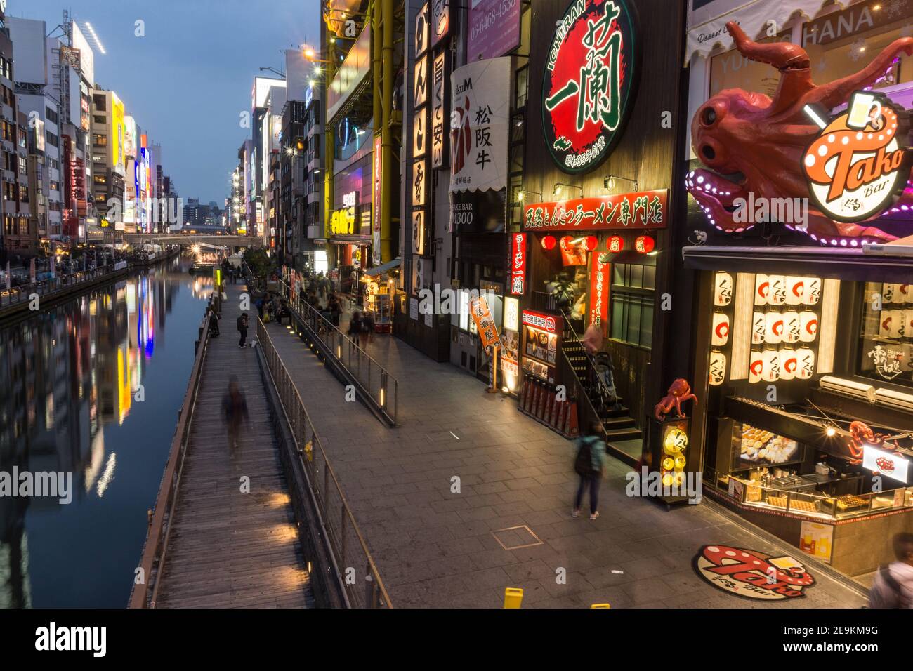 Immagine a lunga esposizione di persone che camminano lungo il fiume Dotonbori ad Osaka, Giappone, una zona famosa per i bar e la vita notturna Foto Stock