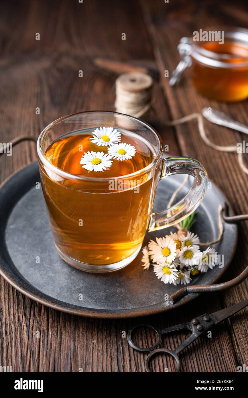 Erboristeria per la salute respiratoria, una tazza di tè margherita con miele su sfondo rustico di legno Foto Stock