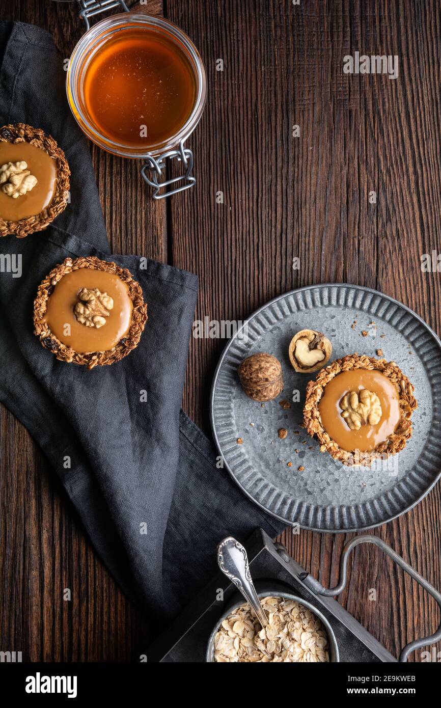 Snack dolce, coppe di granola alla cannella fatte in casa con uvetta e semi di girasole, farcite con toffee, condite con noce Foto Stock