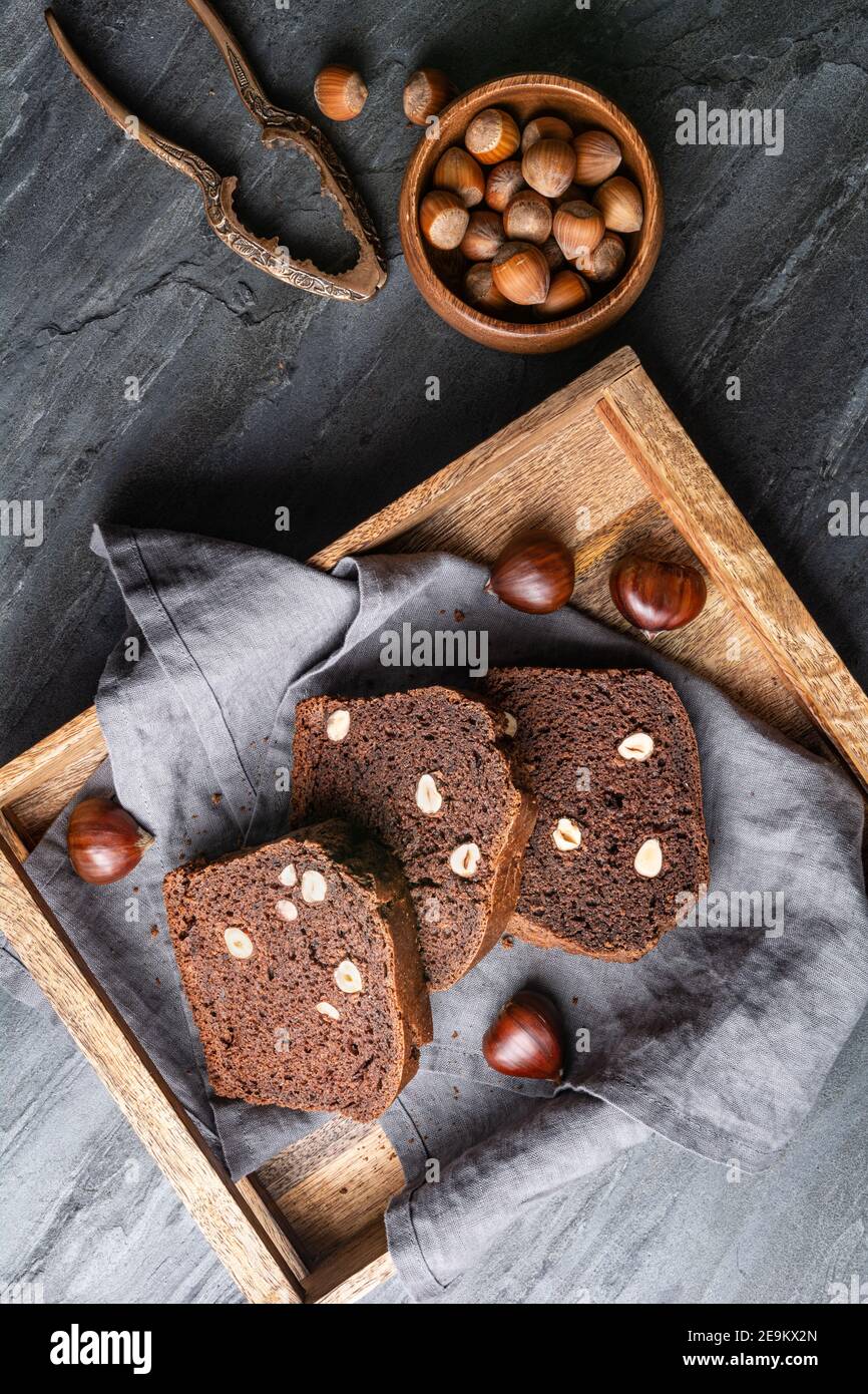 Fette di pane dolce di castagno con cacao e nocciole rustico sfondo in pietra Foto Stock