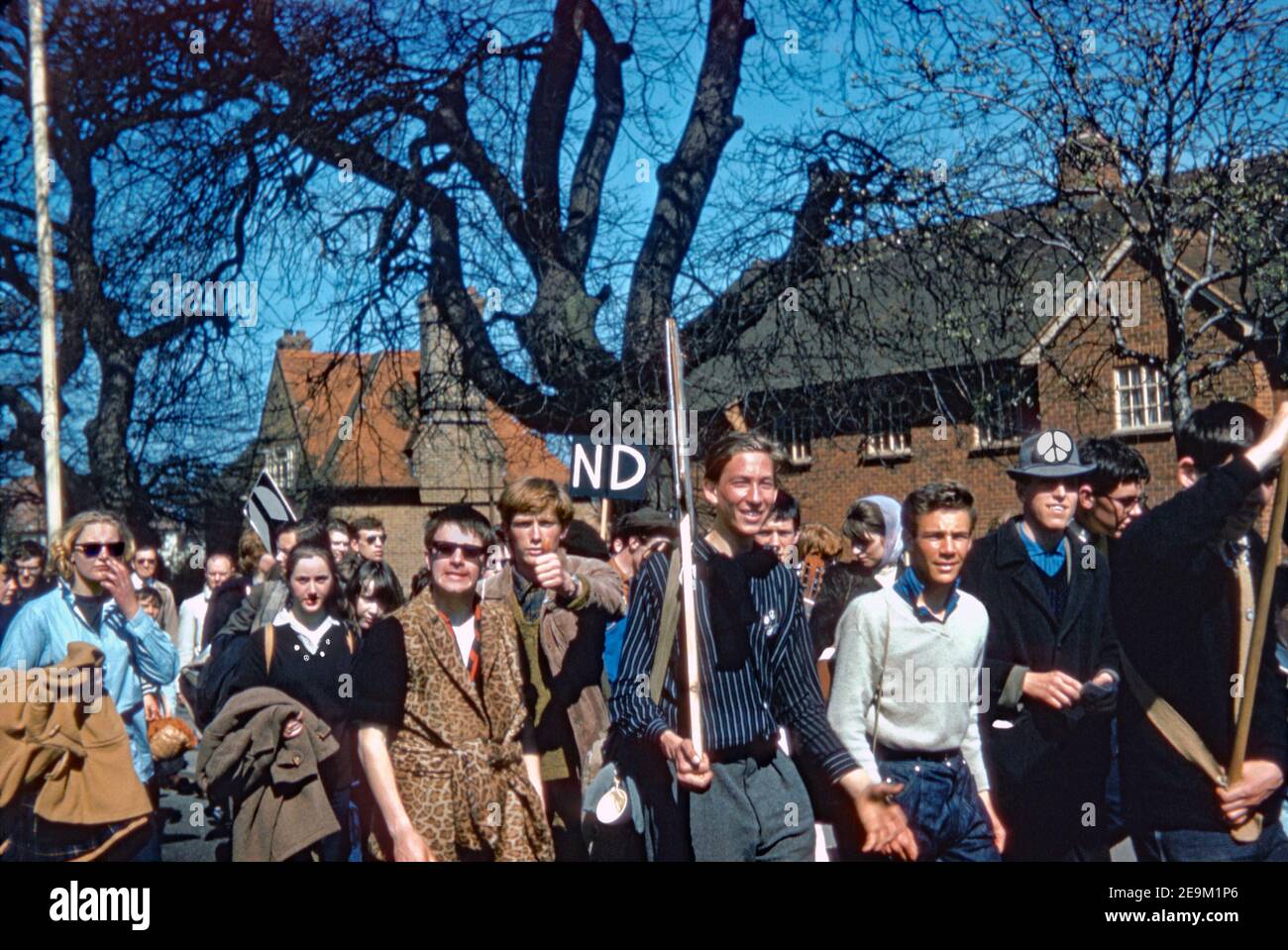 Marchers a ovest di Londra, sulla loro strada per il centro di Londra sulla CND Aldermaston marzo 1962. Visibile è il distintivo logo rotondo bianco e nero progettato per il movimento britannico per il disarmo nucleare nel 1958 – oggi ampiamente considerato come un ‘segno di pace’. Foto Stock