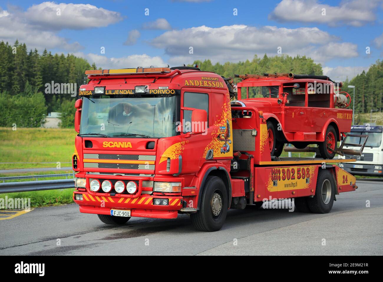 Scania carro attrezzi con pianale di Hinaus Andersson Oy che trasporta un camion fuoco d'epoca. Salo, Finlandia. 6 agosto 2015. Foto Stock