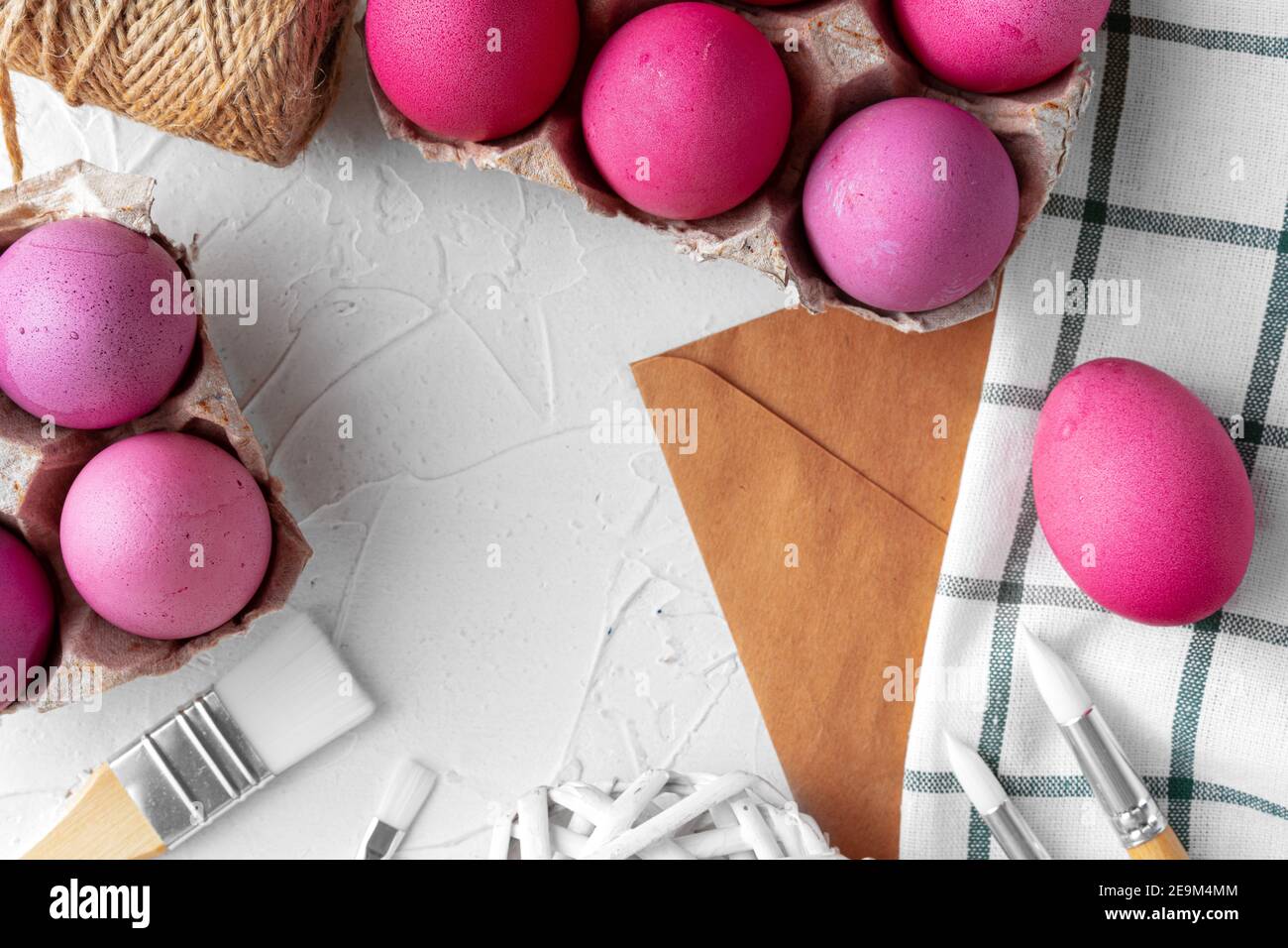 Pittura uova di Pasqua in rosa su tavola bianca, vista dall'alto Foto stock  - Alamy