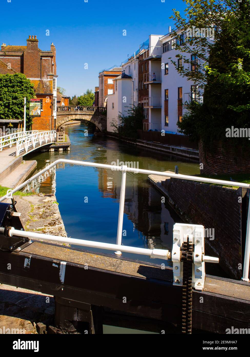 Newbury nel Berkshire, Inghilterra, visto dalle porte di chiusura a West Mills che mostra il ponte sul canale Kennett e Avon nel centro della città. Foto Stock