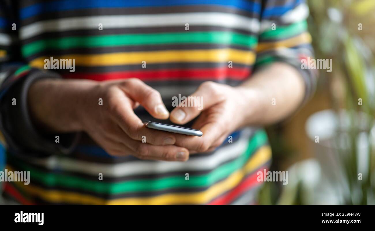 Mani maschili che digitano sullo smartphone Foto Stock