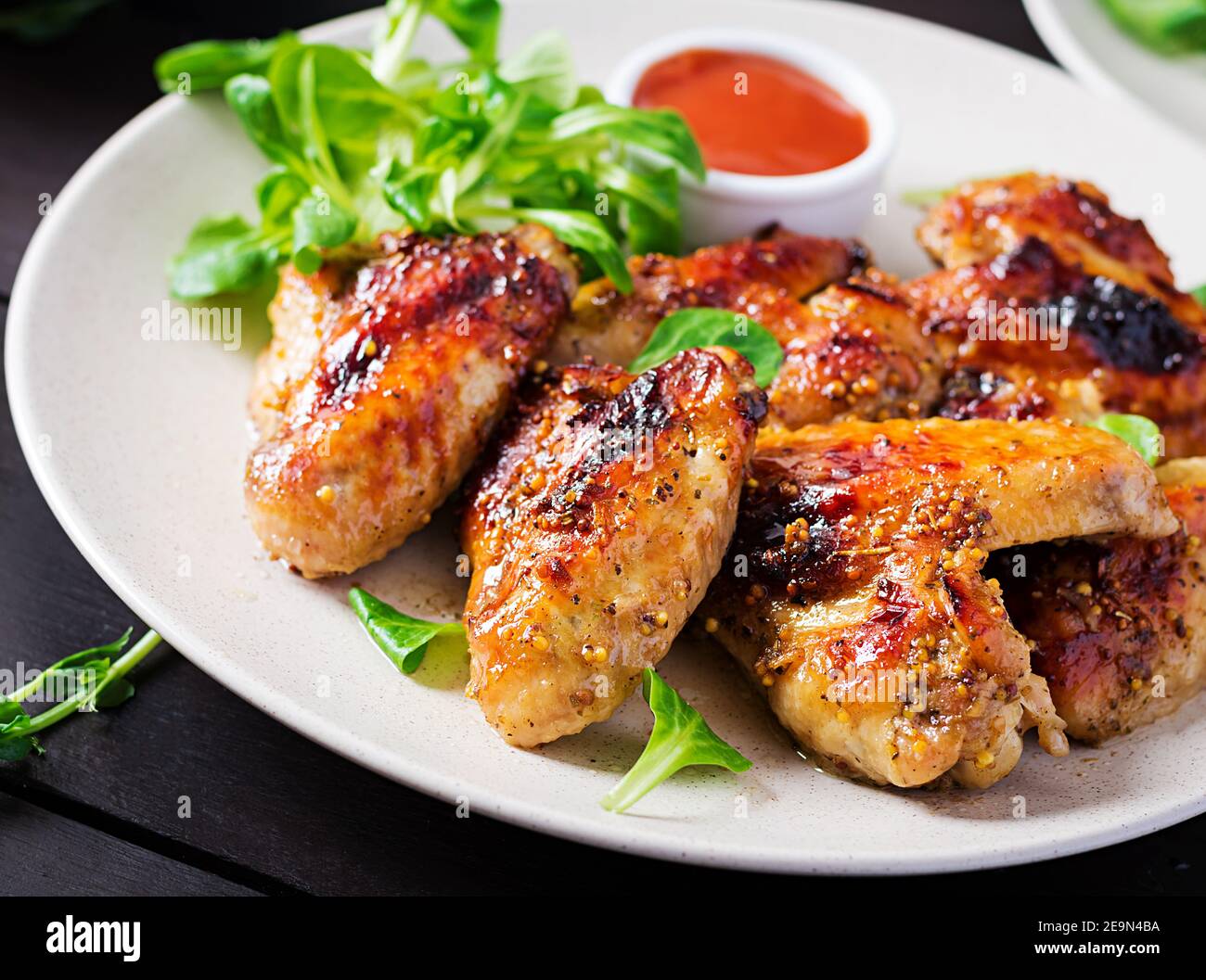 Ali di pollo alla griglia. Ali di pollo al forno su tavolo di legno. Foto Stock