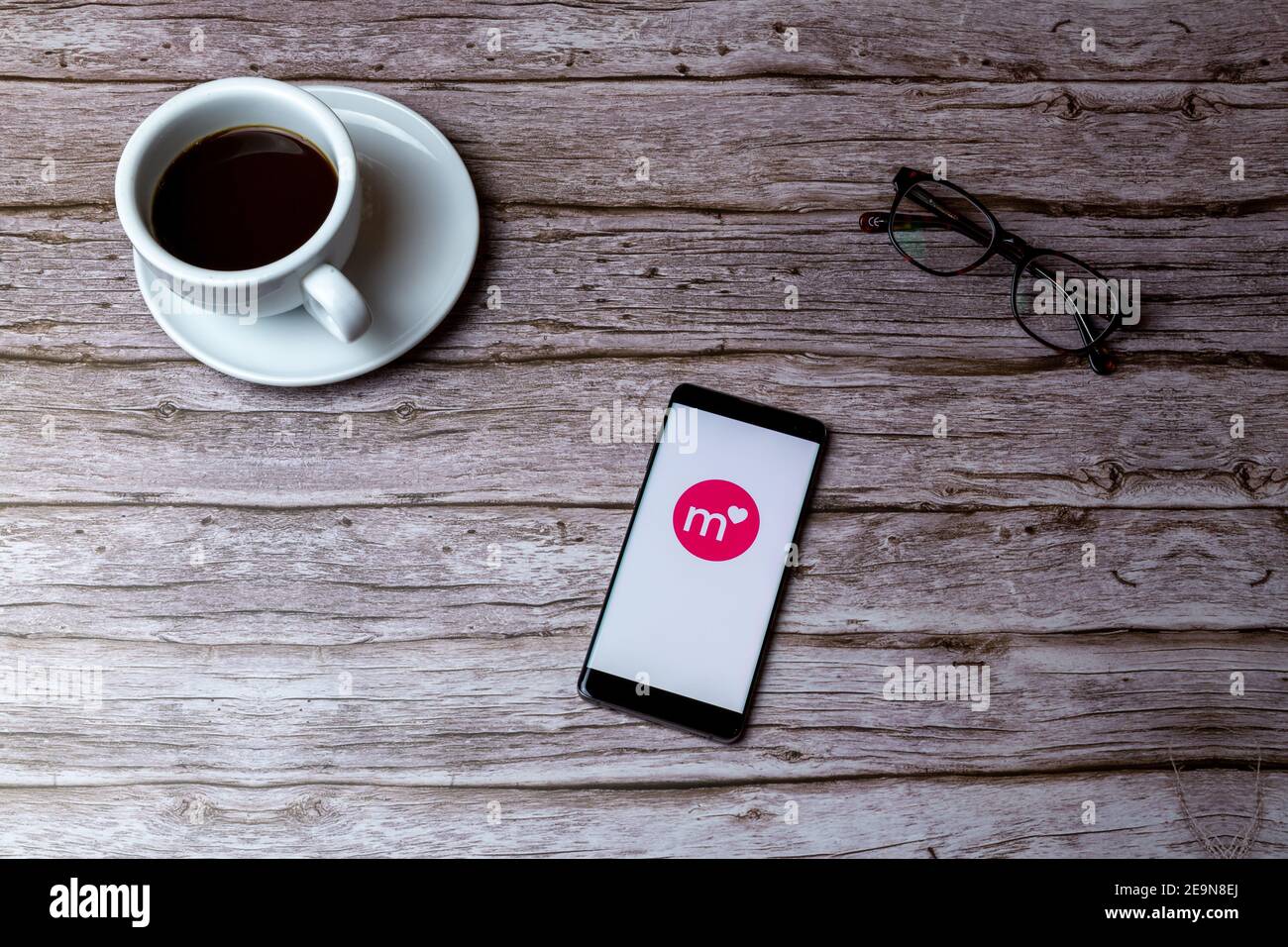 Un telefono cellulare o un telefono cellulare posato su un legno Tavolo o scrivania con l'app Match dating aperta Foto Stock