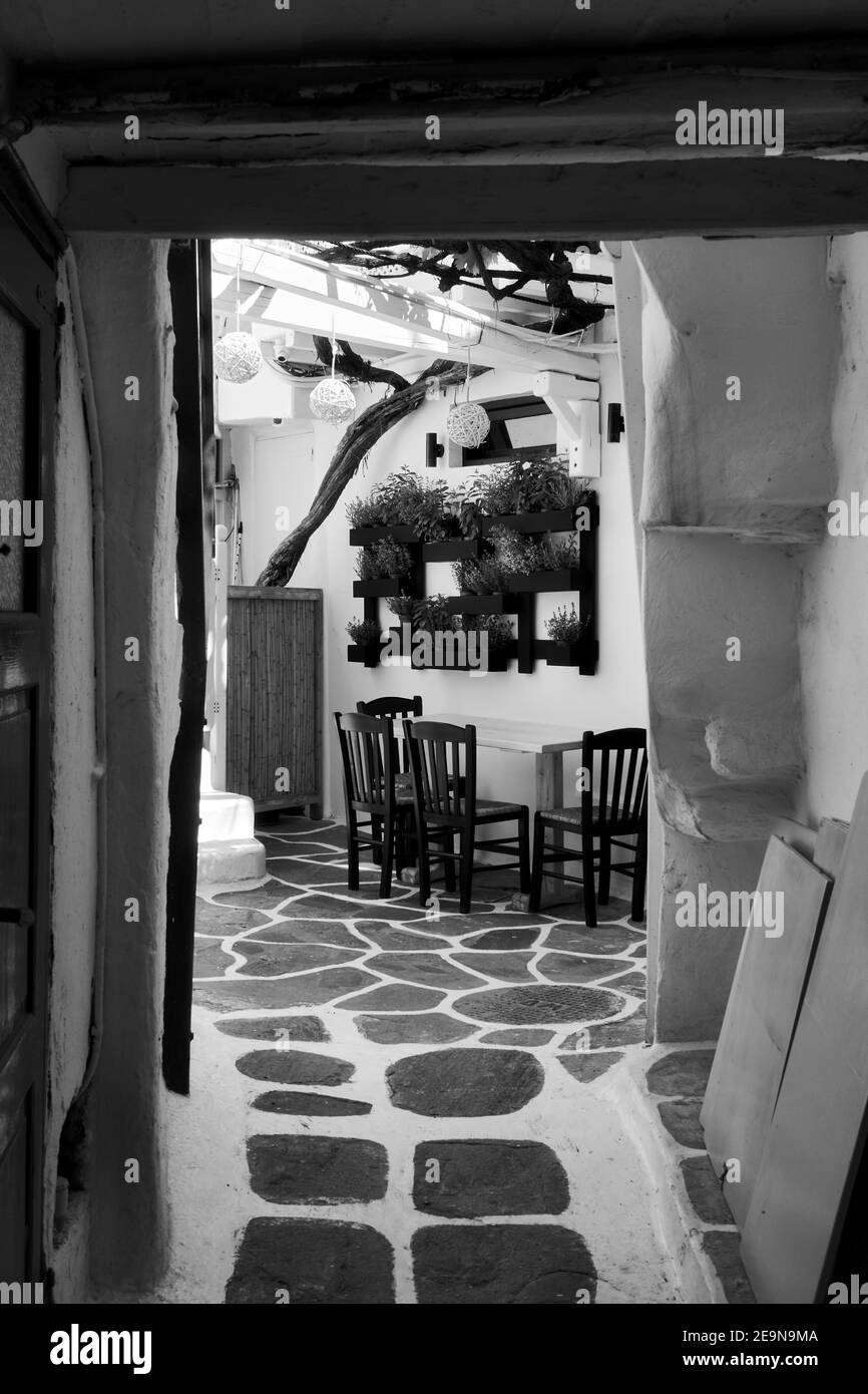 Patio in un piccolo e vecchio cafe nell'isola di Mykonos, Grecia. Fotografia in bianco e nero Foto Stock