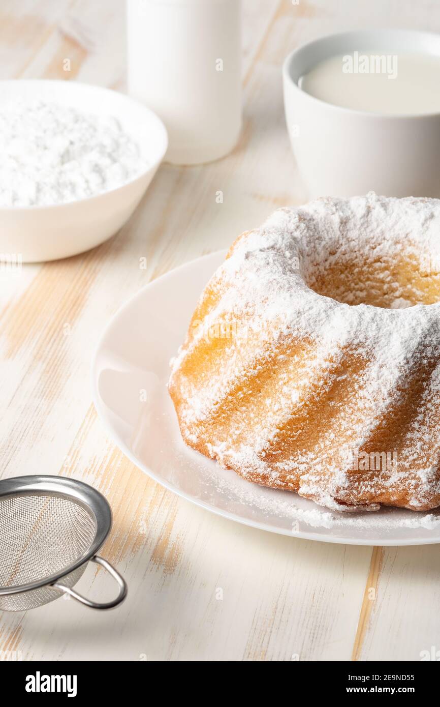 Torta fatta in casa alla vaniglia su sfondo bianco di legno. Foto Stock