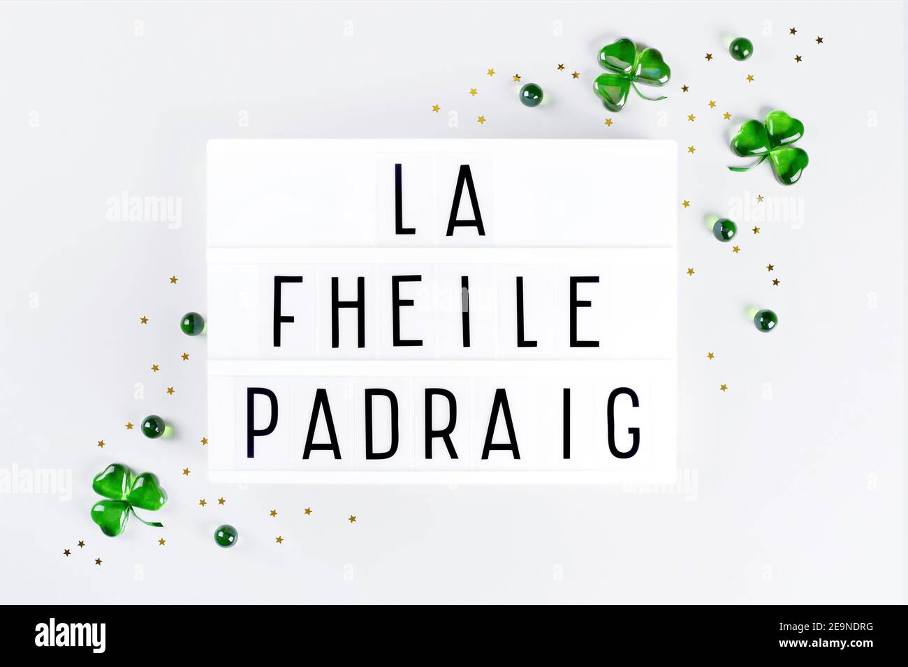 Lightbox con Saint Patricks giorno testo scritto in irlandese e. sciamrocks di vetro verde Foto Stock