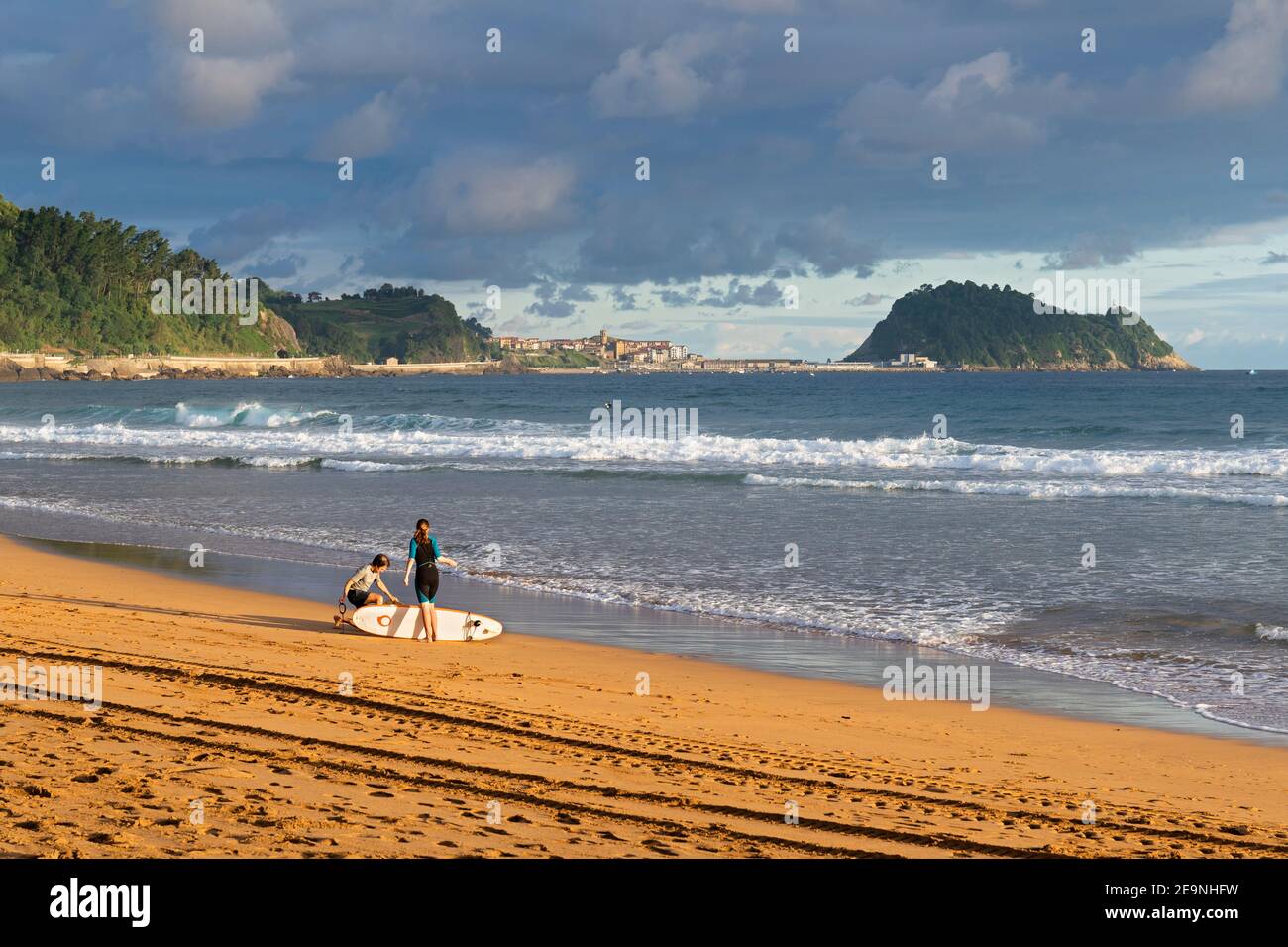 Europa, Spagna, Gipuzkoa, Zarautz Beach con surfisti all'alba Foto Stock