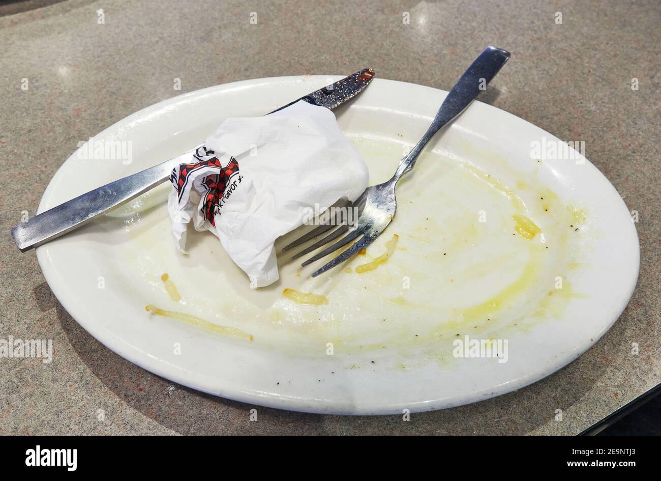 Piatto vuoto sporco con coltello e forchetta dopo colazione pasto di uova in un ristorante. Foto Stock