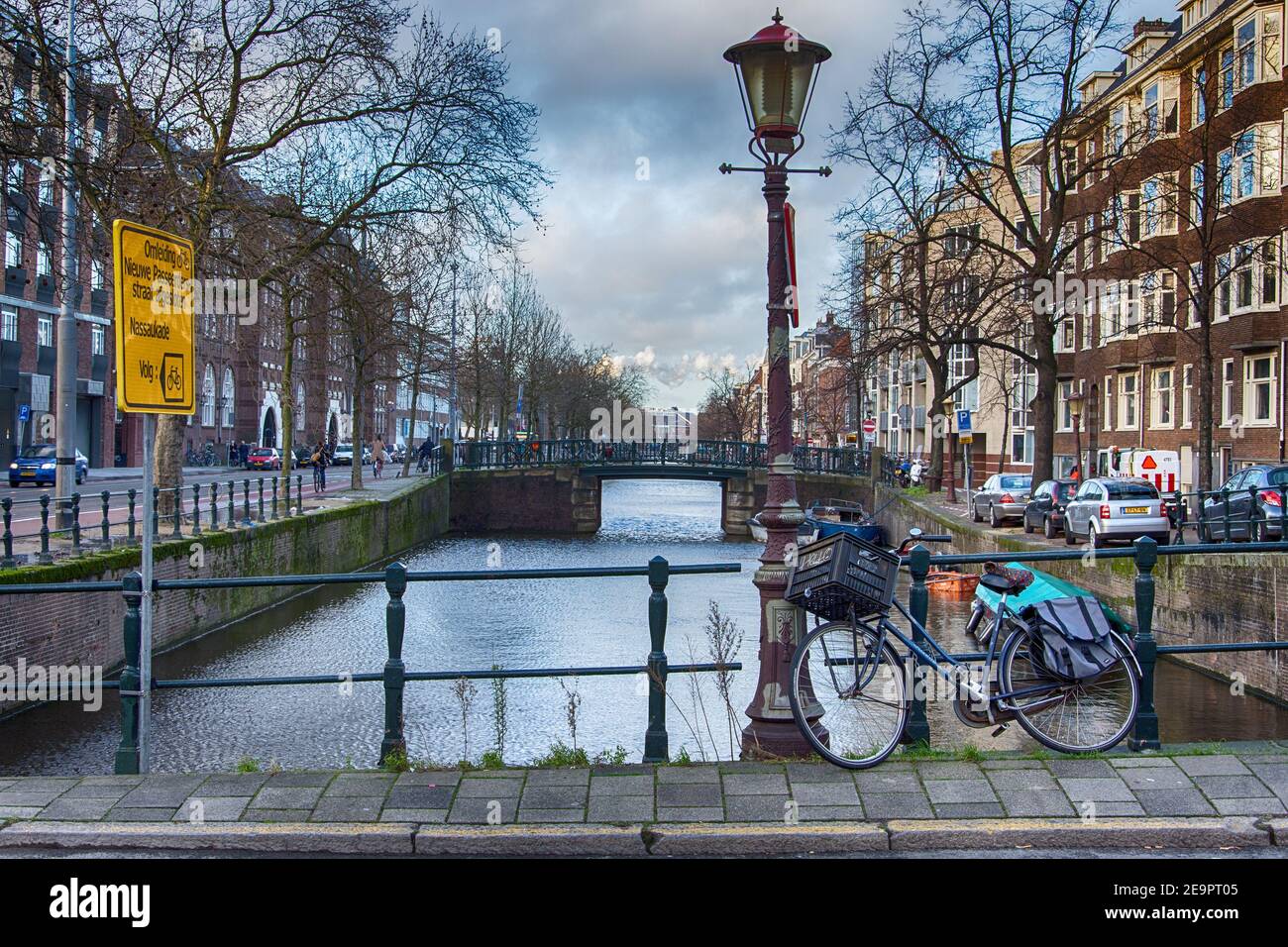 AMSTERDAM, PAESI BASSI - 4 dicembre 2015: Intorno ai canali di Amsterdam, in primo piano una bicicletta, il mezzo di trasporto più utilizzato. Olanda Foto Stock