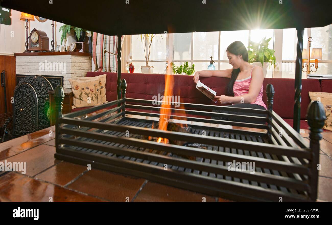 Donna che si rilassa al caminetto nella sala dell'hotel nei Paesi Bassi Foto Stock