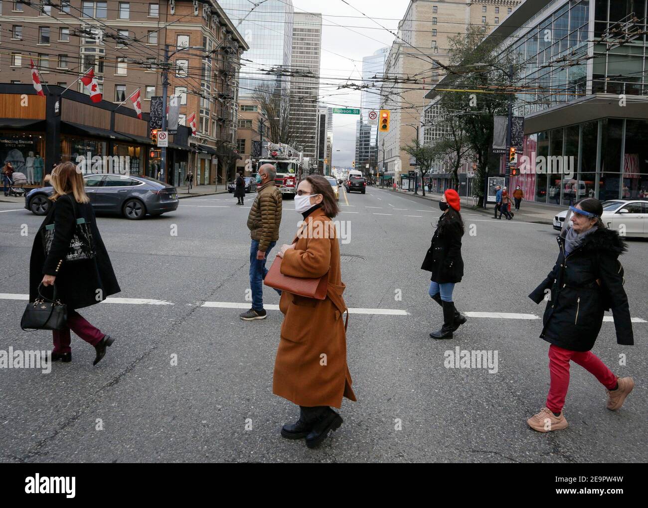 Vancouver, Canada. 5 Feb 2021. Le persone che indossano maschere attraversano una strada nel centro di Vancouver, British Columbia, Canada, il 5 febbraio 2021. Il tasso di disoccupazione in Canada è aumentato di 0.6 punti percentuali a 9.4 per cento in gennaio, il tasso più alto da agosto 2020, ha detto ufficiale Statistics Canada il Venerdì. Credit: Liang Sen/Xinhua/Alamy Live News Foto Stock