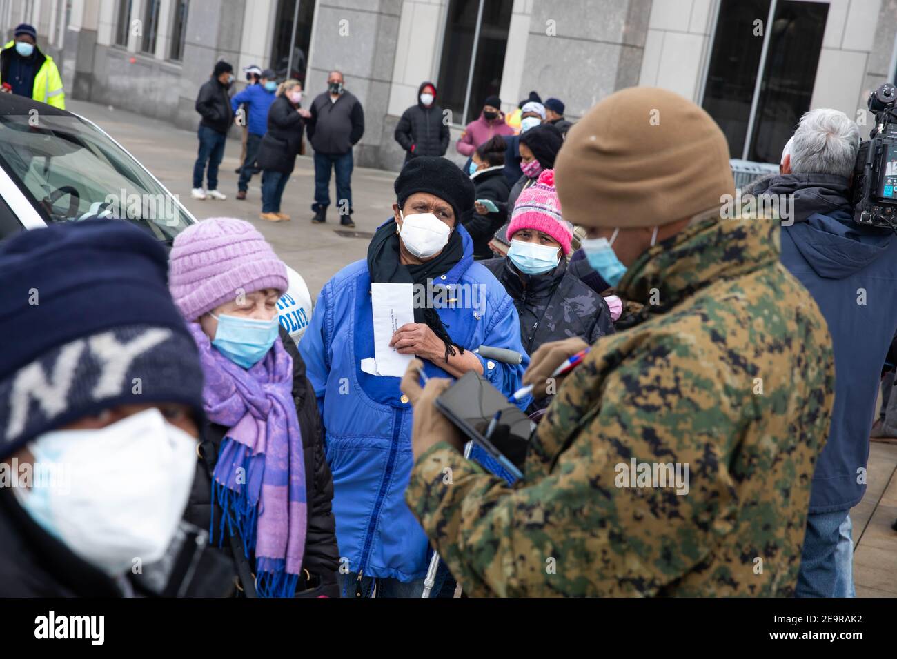 New York, Stati Uniti. 5 Feb 2021. La gente si registra con i membri della National Guard al di fuori del sito di vaccinazione di massa allo Yankee Stadium nel Bronx Borough di New York, Stati Uniti, 5 febbraio 2021. Venerdì è stato aperto un sito di vaccinazione di massa allo Yankee Stadium, dove i residenti idonei del Bronx hanno iniziato a essere vaccinati con nomine. Credit: Michael Nagle/Xinhua/Alamy Live News Foto Stock