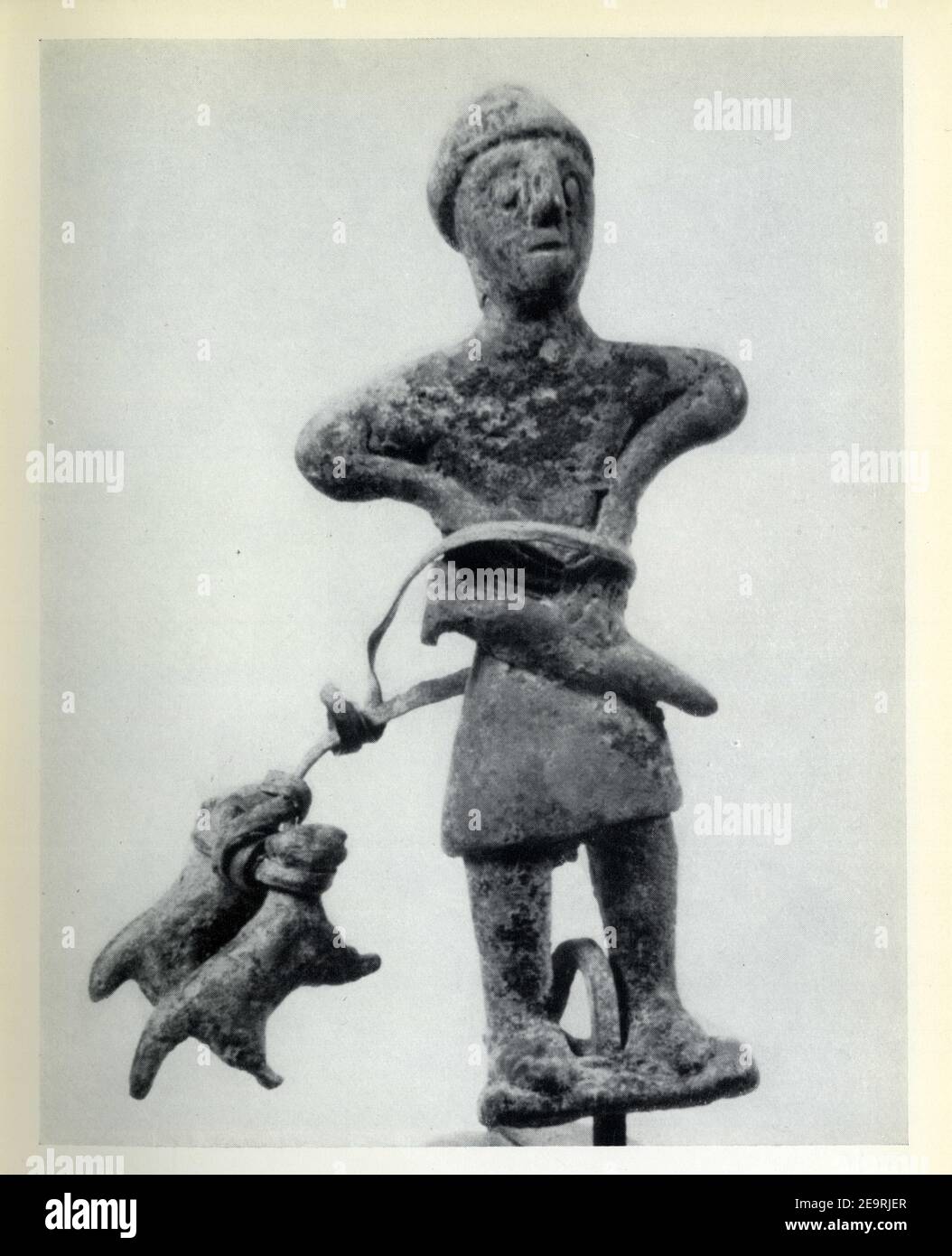 Personnage en bronze armé de poignard, tenant en laisse deux chiens. Iran. Luristan. VIII-VIIe siècle avant J.C. Foto Stock