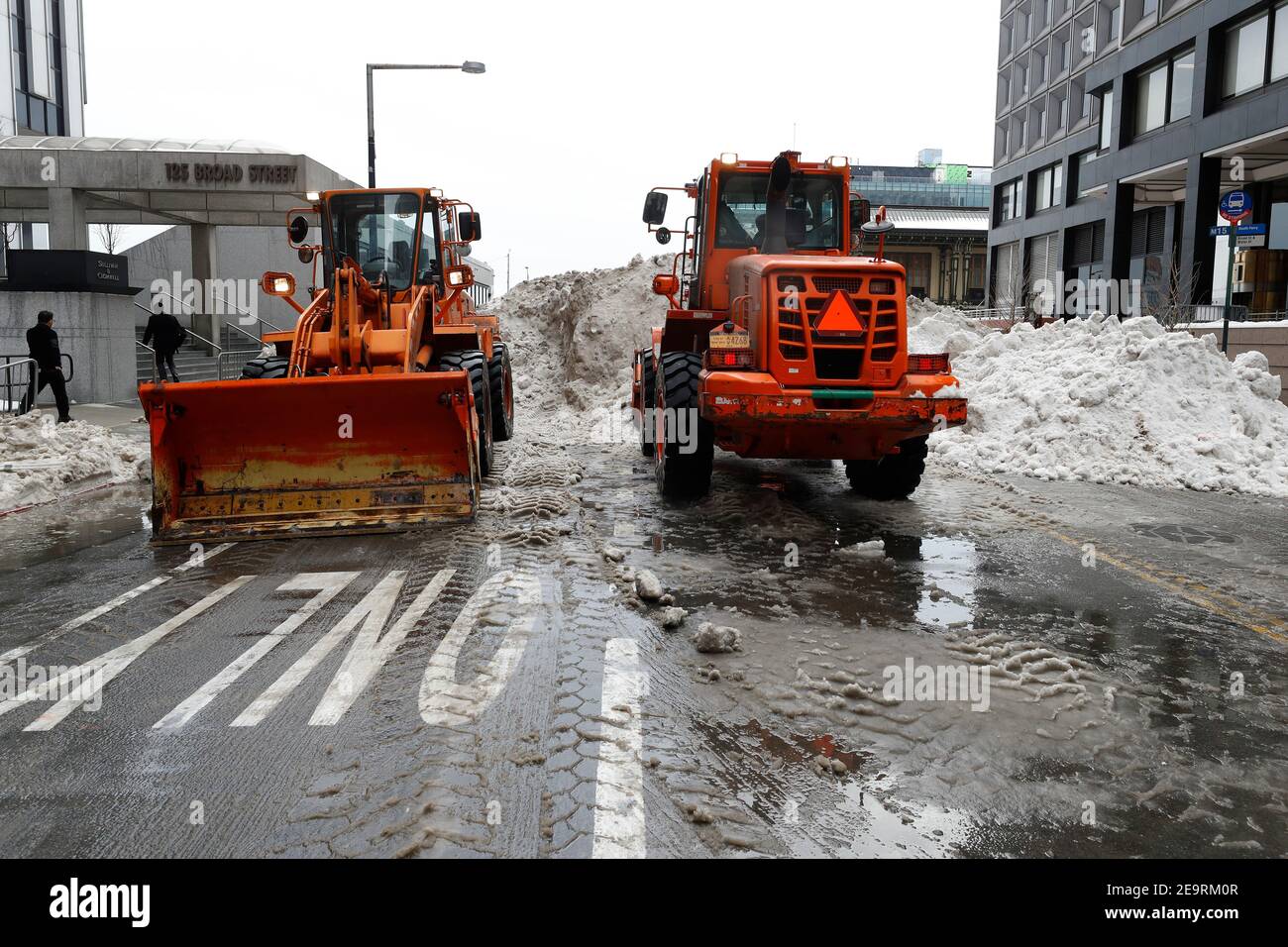 Davanti e i caricatori utilizzati per caricare la macchina per lo scioglimento della neve sono visti parcheggiati vicino all'area di raccolta della neve.giorni dopo la prima Nor"di New York, Pasqua del 2021, la città si trova di fronte al compito di smaltire la neve. Diverse località in tutta la città sono state allestite con macchine per lo scioglimento della neve in grado di gestire da 60 a 130 tonnellate all'ora. Foto Stock