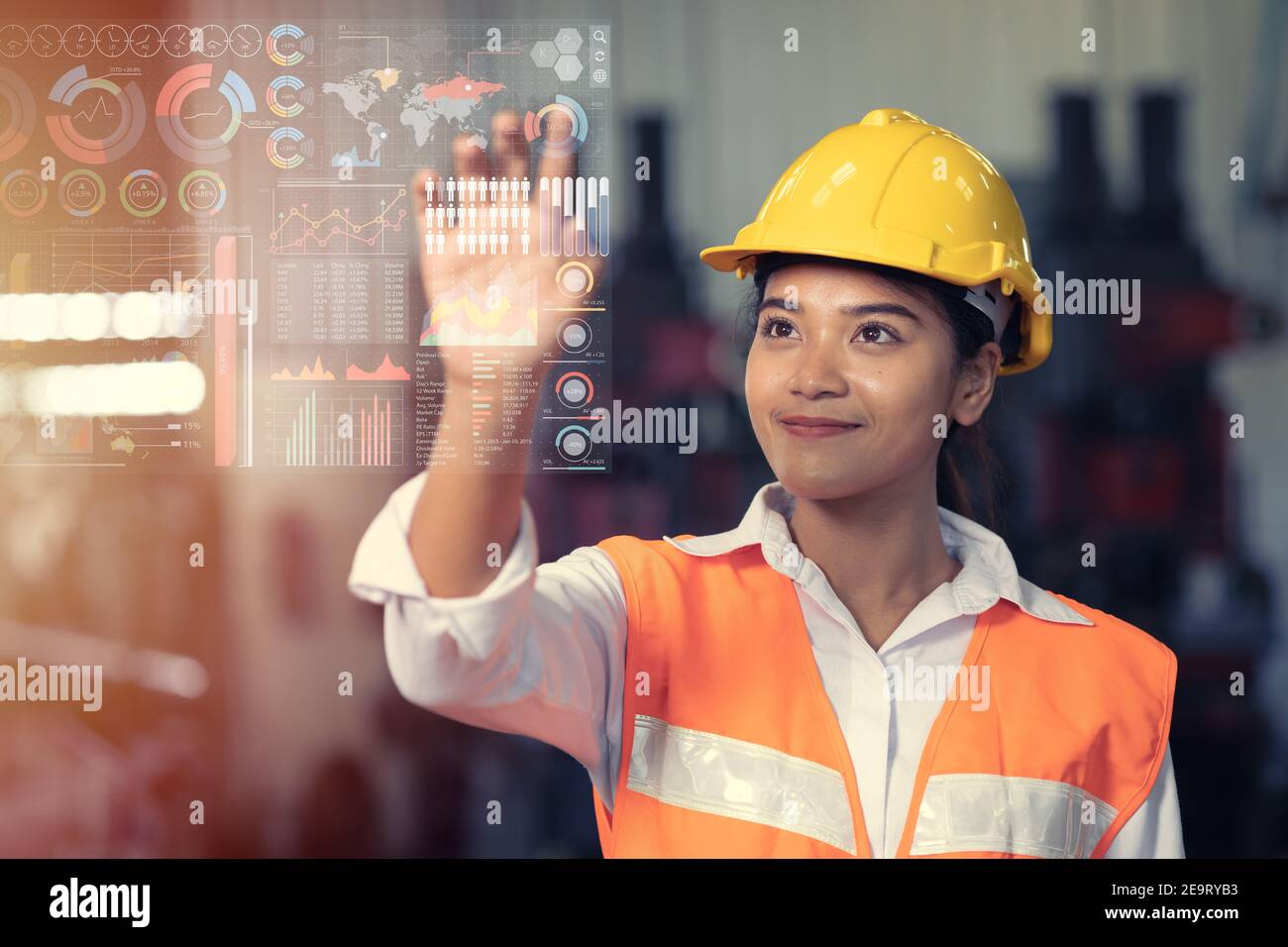 Ingegnere lavoratore utilizzando tecnologia avanzata digitale ologramma infografica touch panel in fabbrica del settore. Foto Stock