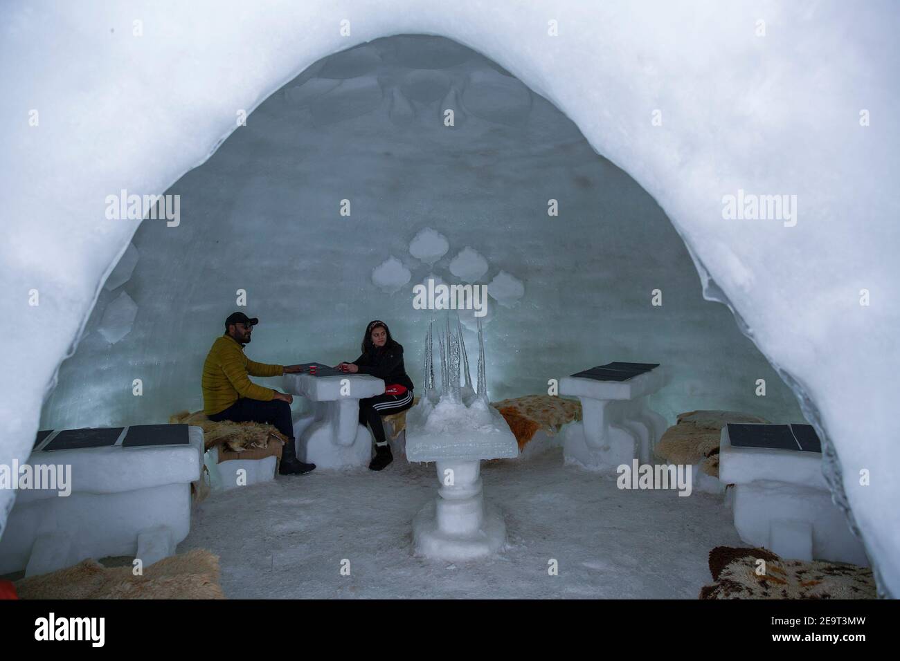 Srinagar, Kashmir controllato dall'India. 5 Feb 2021. I turisti hanno il tè all'interno di un igloo cafe a Gulmarg, a circa 48 km a nord della città di Srinagar, la capitale estiva del Kashmir controllato dagli Indiani, il 5 febbraio 2021. Il caffè igloo è diventato un'attrazione turistica in una stazione sciistica di Gulmarg. Credit: Javed Dar/Xinhua/Alamy Live News Foto Stock